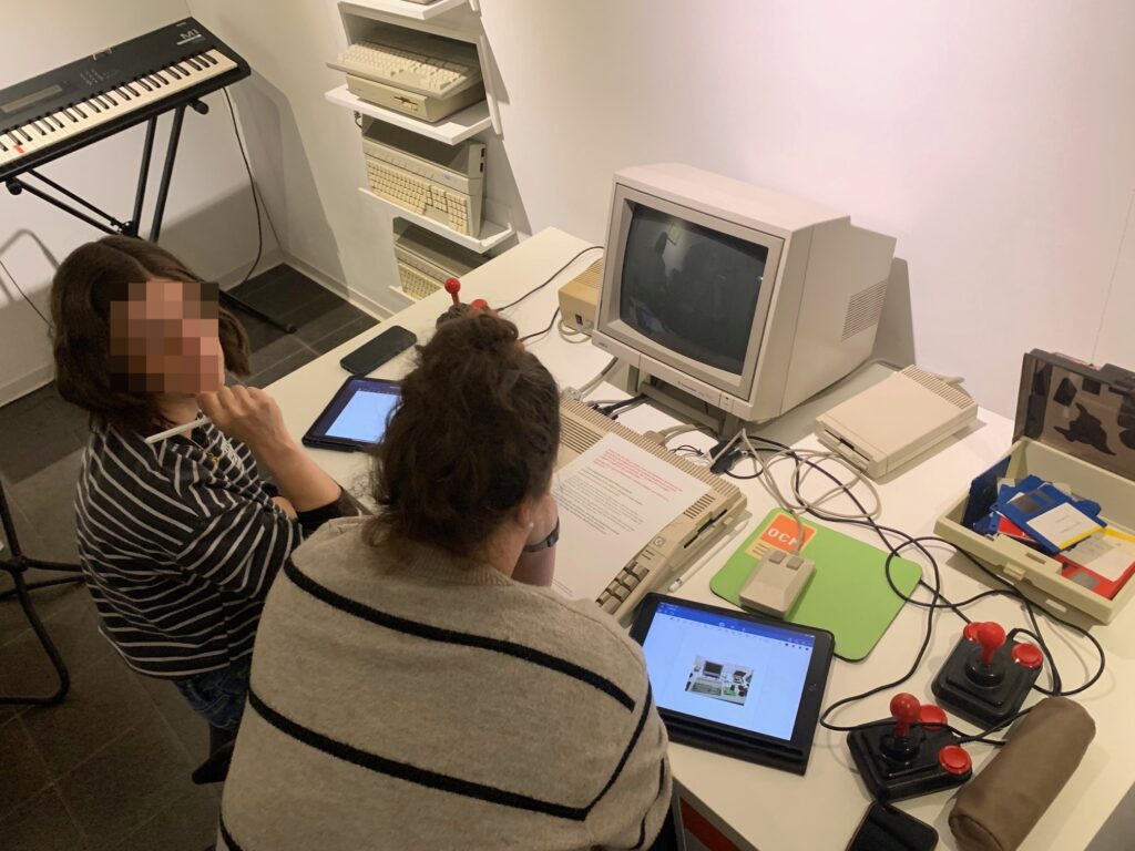 Studierende vor einem alten Computer